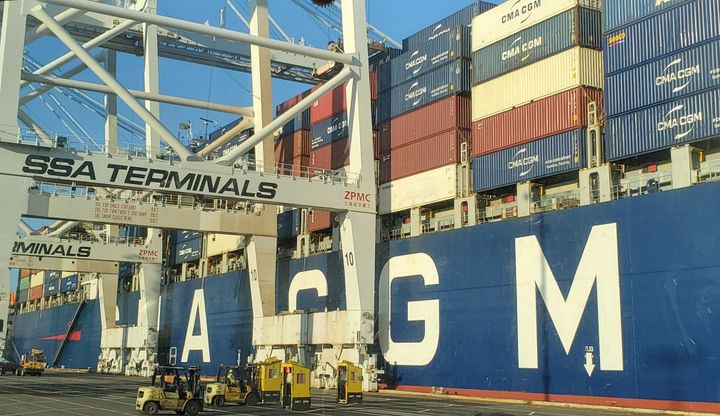 A large ship filled with containers waiting to be unloaded by cranes labeled "SSA Terminals."